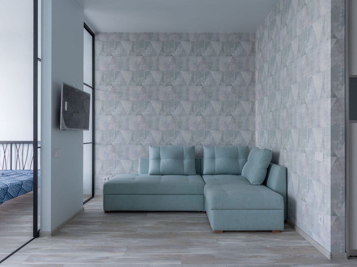 Contemporary living space with a textured geometric wallpaper accent wall and soft seating