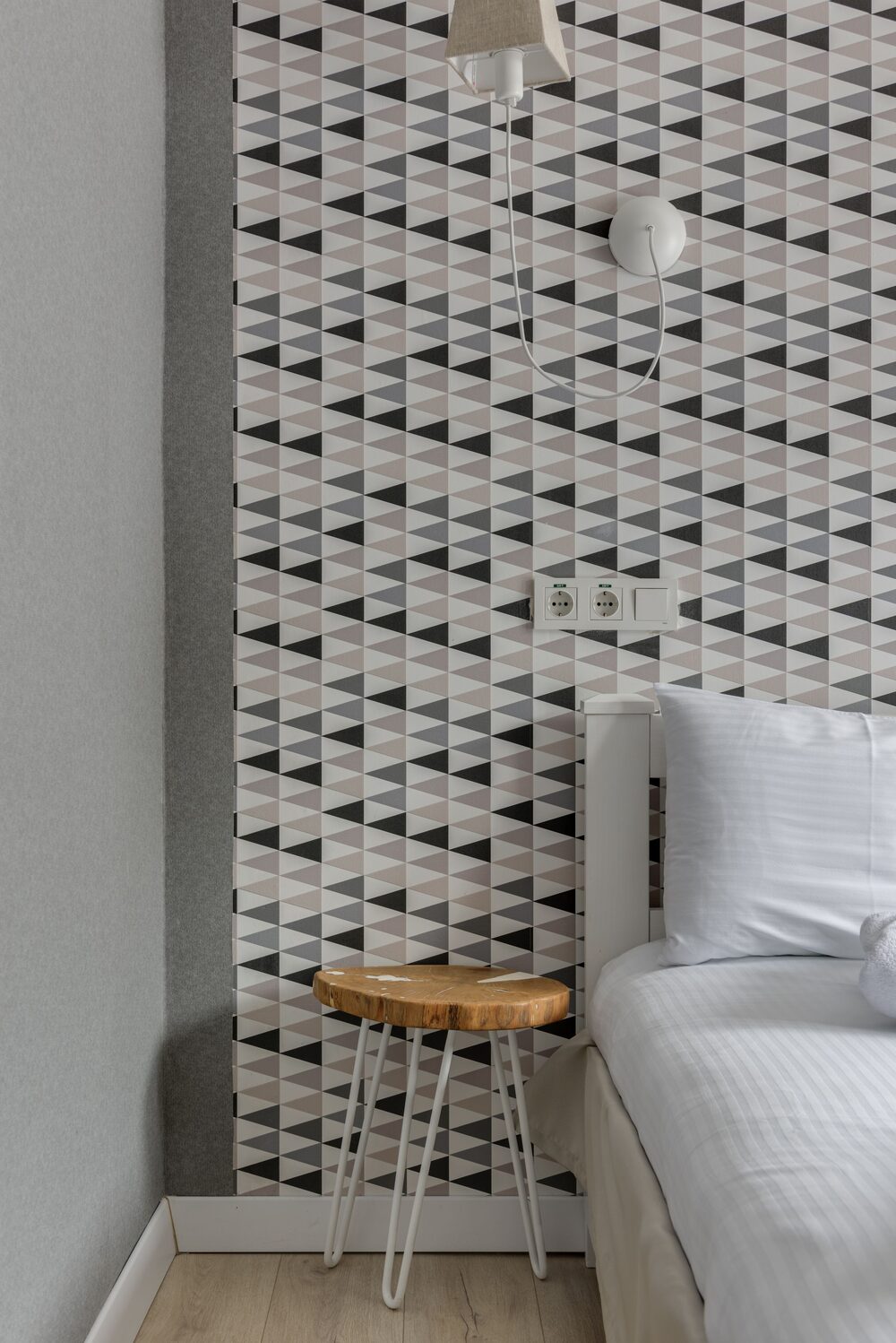 Bedroom corner with crisp black and white geometric wallpaper