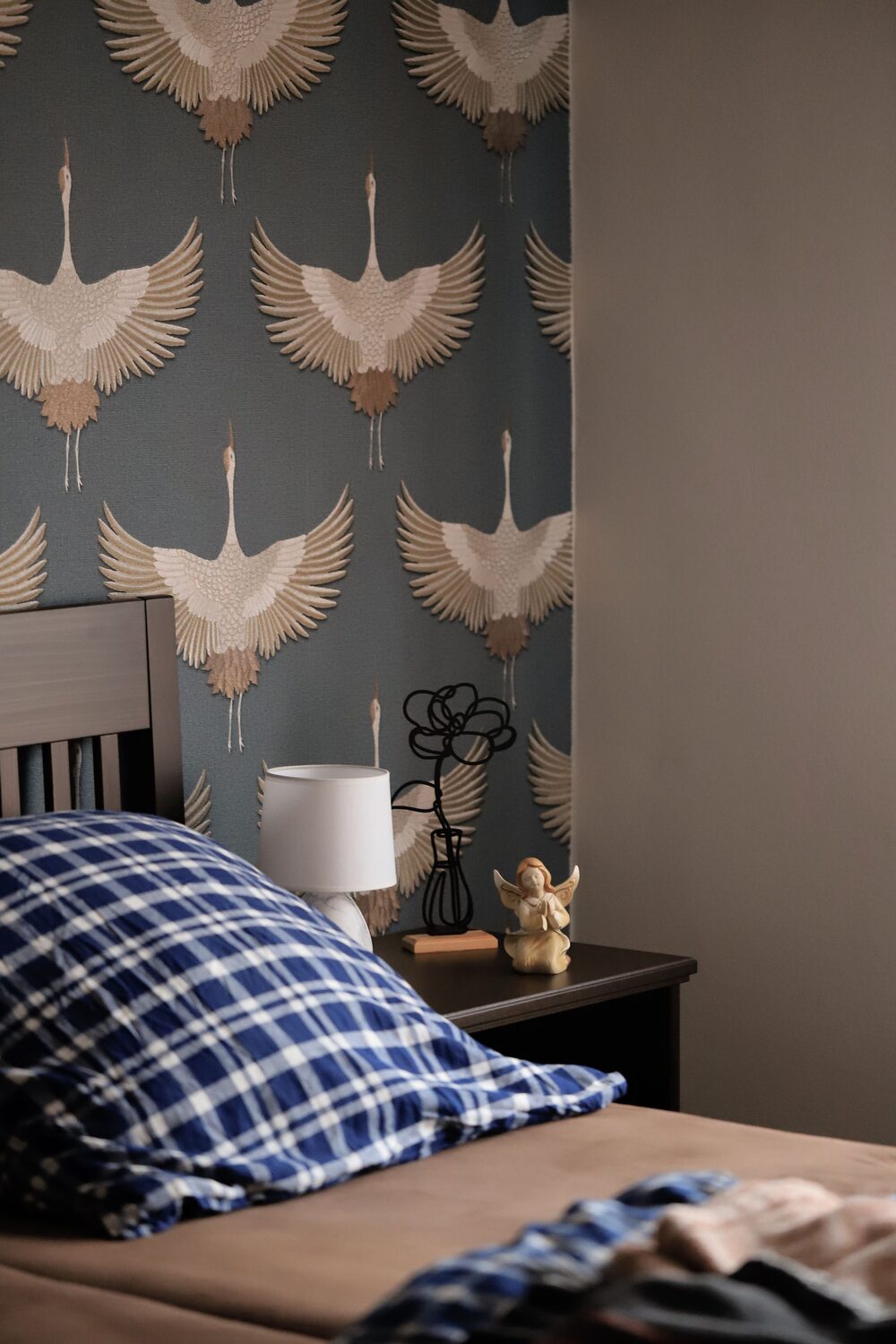 Bedroom with elegant crane chinoiserie wallpaper in muted blue tones
