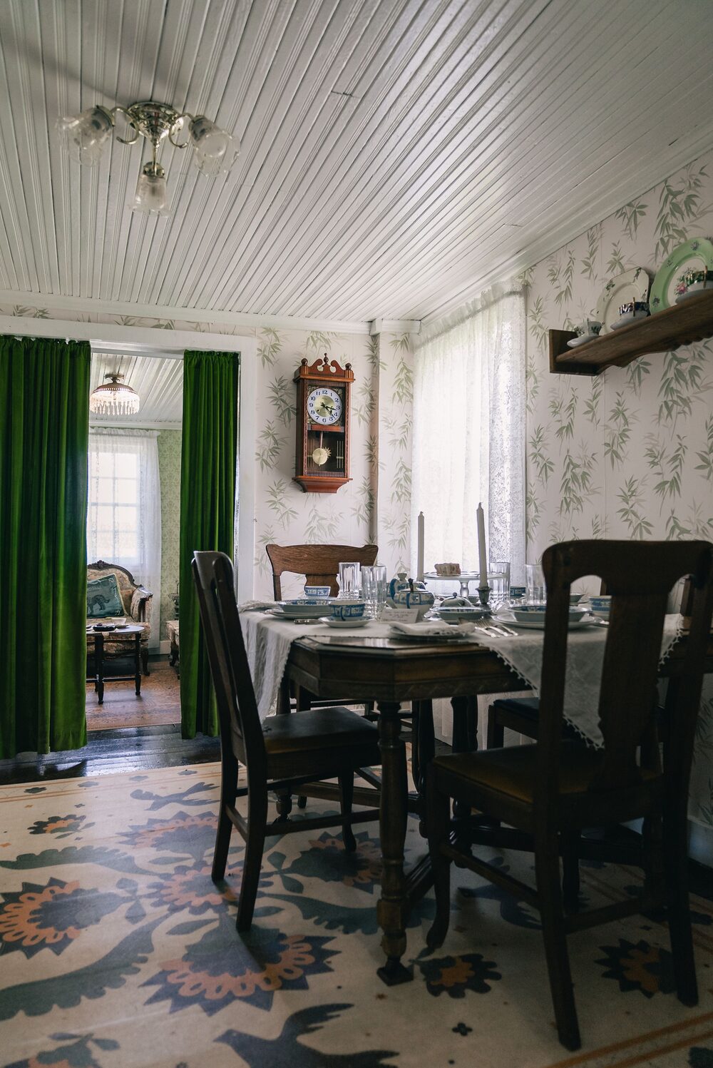 Traditional dining room with patterned wallpaper and antique furniture